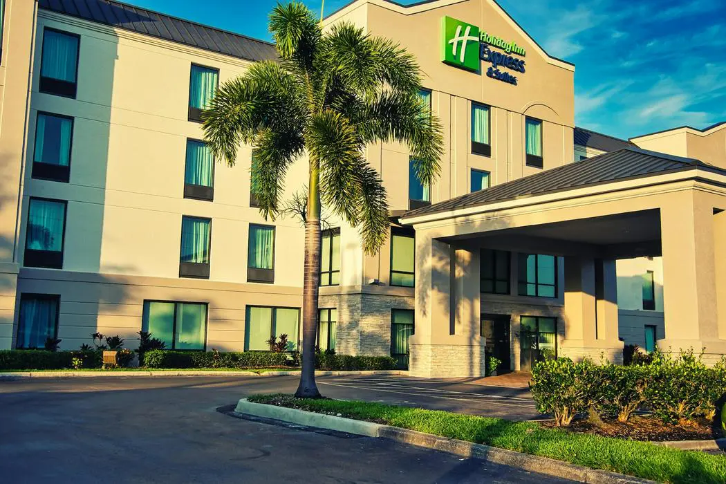 A palm tree in front of a hotel.