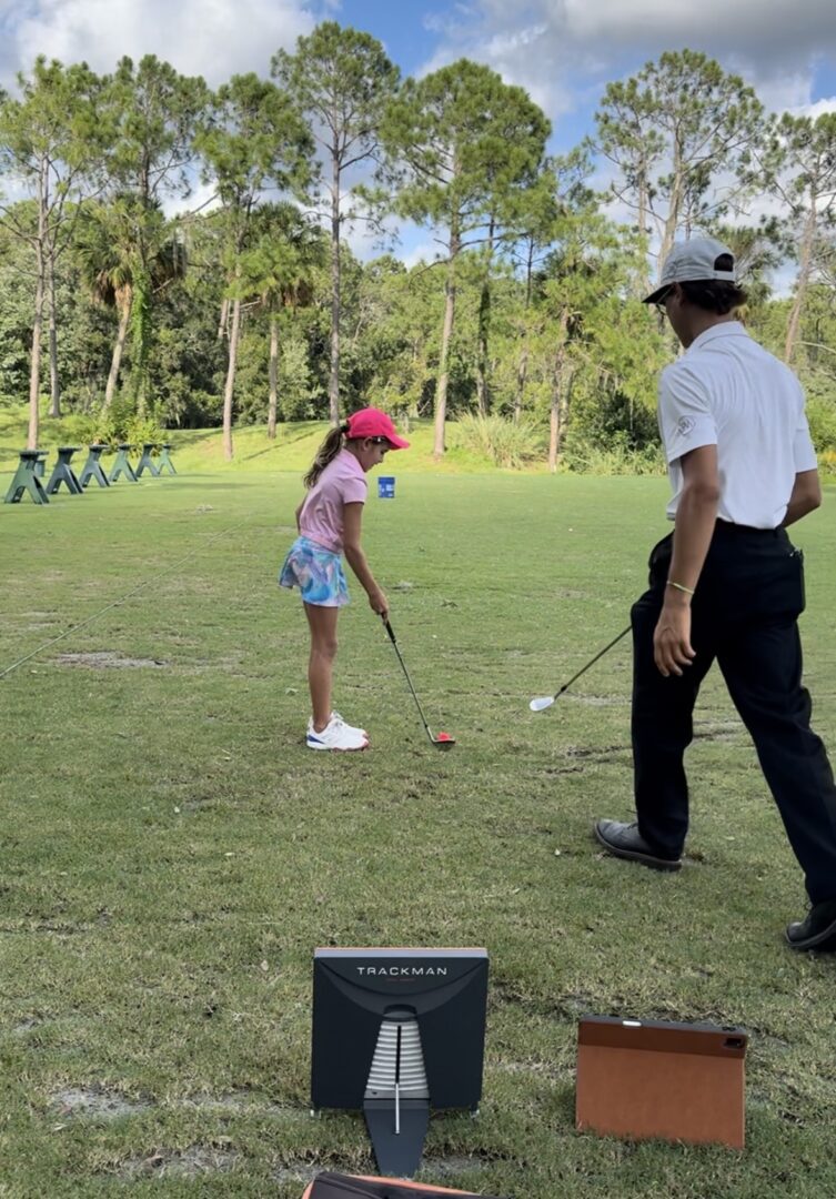 Screenshot A man and girl playing golf on the grass.