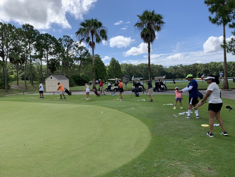 A group of people on the grass playing golf.