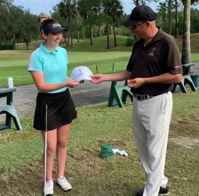 A man and woman are standing on the golf course.