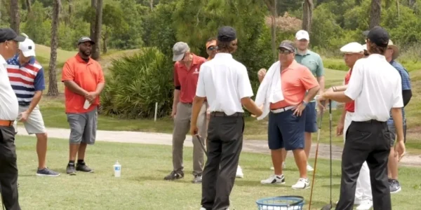 People on a golf course with a golf bat