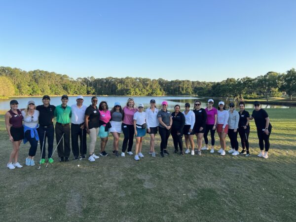 A group of people standing on top of a grass covered field.