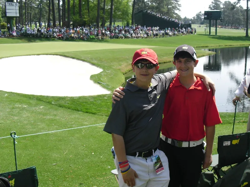 Two young men pose for a picture on the golf course.